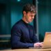 man in black long sleeve shirt using macbook