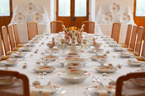 a table set for a formal dinner with deer heads on the wall