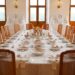 a table set for a formal dinner with deer heads on the wall